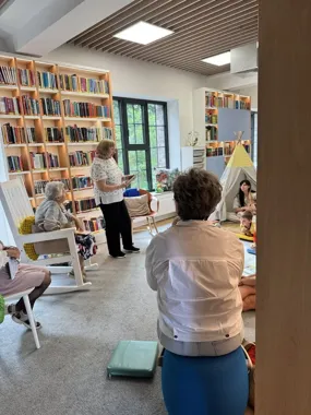Grafika promocyjna wydarzenia Seniorzy czytają dzieciom — spotkanie czytelnicze w bibliotece